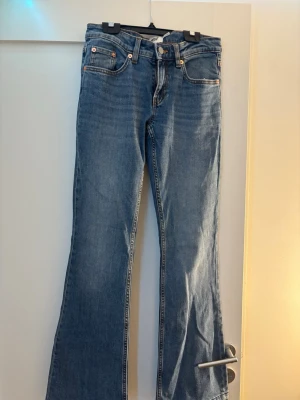 Blå bootcut jeans  - Säljer ett par klassiska blå bootcut jeans. dom är lågmidjade men dock har jag sprättat upp dom nere vid benen men inget som stör 