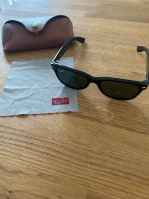 Ray-Ban Wayfarer Classic Polarized - Säljer ett par riktigt snygga klassiska Ray-Ban som är polariserade. I mycket gott skick men tappade dem så ena glaset fick en rejäl spricka. I övrigt knappt använda. Fås i original läderfodral med trasa för rengöring.  Nypris: 1500 SEK Mitt pris: 389 SEK  Skickas alltid snabbt och spårbart (ofta samma dag) eller hämtas i Glumslöv.  Hör av dig vid frågor och se gärna mina andra annonser också!