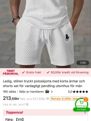 Vitt set med strukturmönster och häst - Säljer ett vitt set med strukturmönster som består av en kortärmad topp och shorts. Setet har ett svart hästtryck på shortsen och dragsko i midjan. Materialet ser ut att vara mjukt och luftigt, perfekt för en avslappnad look.