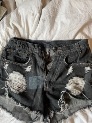 Svarta Levi's jeansshorts med slitningar - Jätte coola shorts från levi’s som är högmidjade 