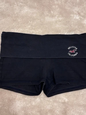 Hollister fold over shorts - Hollister fold over shorts in very dark navy blue or black, can’t tell. Size Small, has signs of usage like some lint on it