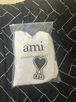 AMI Paris T-shirt – Unisex Strl M  - Säljer en stilren AMI Paris t-shirt i storlek M. Tröjan är unisex och passar även storlek S om du vill ha en snygg oversized fit. Endast testad, alltså i nyskick. Originaltagg och originalpåse medföljer.  ✅ Märke: AMI Paris ✅ Storlek: M (Passar även S oversized) ✅ Unisex ✅ Färg: Vit ✅ Endast testad – nyskick ✅ Originaltagg och originalpåse medföljer ✅ Mjukt och bekvämt material  💬 Pris kan diskuteras vid snabb affär. 📦 Skickas inom 24 timmar efter betalning. 📸 Se bilder för egen bedömning skick