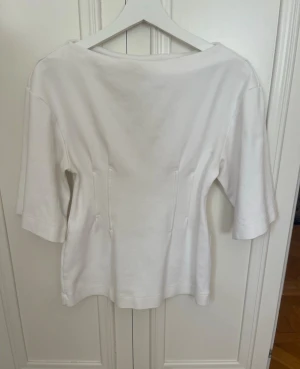 Vit T-shirt från HM intagen midja trekvartsärm - Vit T-shirt från HM intagen midja trekvartsärm, storlek XS, lite missfärgad inuti se sista bilden