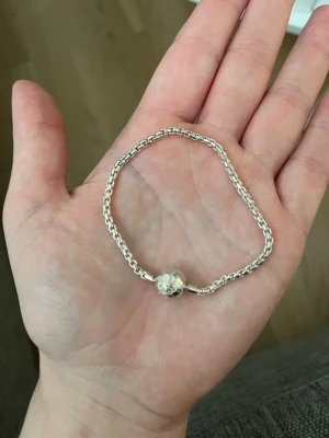 Silverarmband från Thomas Sabo - Snyggt armband i silverfärgat metall från Thomas Sabo. Armbandet har ett runt lås med ingraverad logotyp och dekorativ detalj. 
