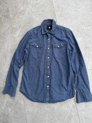 Blå slim fit skjorta från G-Star RAW - Säljer en blå slim fit skjorta från G-Star RAW, storlek M, herr. Fint skick.