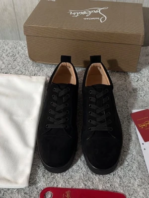 Christian Louboutin i Size 43 - Stilrena svarta sneakers i mocka med svarta skosnören och diskret design. Låg modell med mjuk innersula och klassisk siluett. Passar perfekt till jeans eller chinos för en clean look