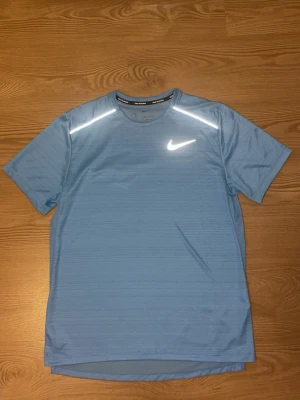 Ljusblå Nike tränings-tshirt - Säljer en ÄKTA ljusblå Nike Miler T-shirt kvitto finns om man undrar. Skriv om du undrar något. DET ÄR FAST PRIS 