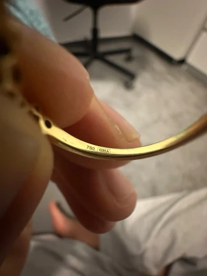 Guldring med rosa och vita stenar - Säljer en elegant ring i 18K guld med gnistrande rosa och vita stenar i ett mönster runt hela ringen. Ringen har en tunn, klassisk form och är stämplad med 750. Perfekt för dig som gillar färg och vill ha något unikt.