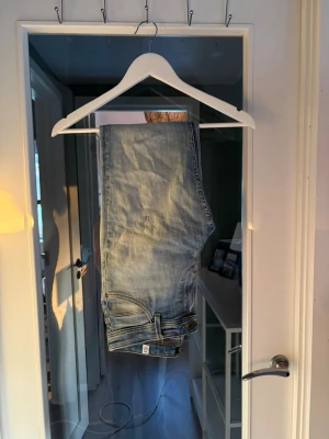 Ljusblå jeans från Jack & Jones - Säljer ett par ljusblå jeans från Jack & Jones med klassisk femficksdesign och skinnpatch bak. Jeansen har raka ben och är tillverkade i denim med snygg tvättad look. Perfekta för en avslappnad stil.