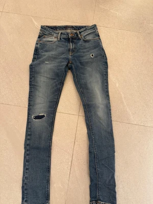 NUDIE jeans - Säljer dessa snygga nudie jeans med slitningar och lite tvättning på framsidan. Skick : 8/10 pris :-399 ordinarie pris:-1299.   W28 L32