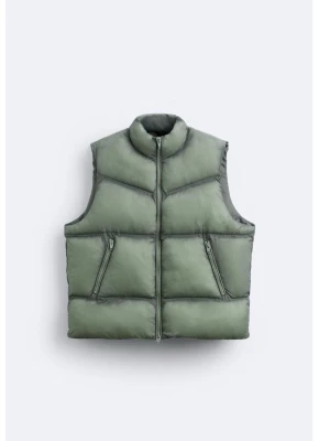 Grön dunväst från Zara - Stilren grön dunväst från Zara med hög krage och dragkedja framtill. Västen har två snedställda fickor med dragkedja och quiltad design som ger en modern look. Perfekt för lager-på-lager och enkel att matcha till olika outfits.