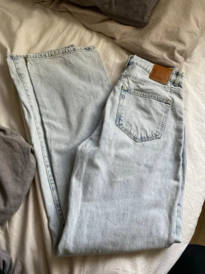 Ljusblå raka jeans från Never Denim - Säljer ett par ljusblå jeans från Never Denim med rak passform och klassisk femficksdesign. Jeansen har en snygg vintagekänsla och är tillverkade i bomullsdenim. Endast använda en gång, pruta om så behövs☺️