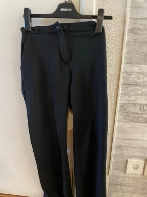 Svarta kostymbyxor  - Snygga svarta kostymbyxor går att ändra storleken i midjan. Är i storlek 160 men passar även som xs/s