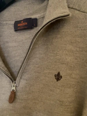 Beige halvzip tröja från Morris - Snygg beige stickad tröja från Morris med 100% merino. Tröjan är väldigt enkel o passar med det mesta.. Tillverkad i mjukt material som känns skönt mot huden.