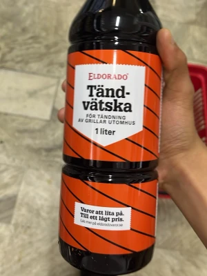 Eldorado Tändvätska 1 liter - En flaska tändvätska från Eldorado på 1 liter, perfekt för att tända grillar utomhus. Flaskan är svart med orange etikett och tydlig text. Enkel att använda när du vill få igång grillen snabbt och smidigt.