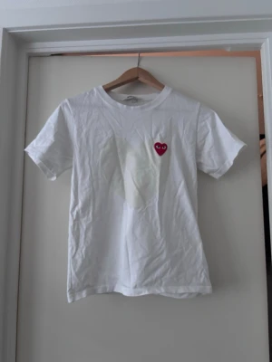 Comme des Garçons t-shirt - En riktigt fräsch t-shirt, perfekt för dig som vill ha på dig något fett i sommar/höst. Den är 100% autentisk och har den klassiska röda loggan på bröstet. Använd ett fåtal gånger. Priset är ej hugget i sten. Skriv vid funderingar!🤗