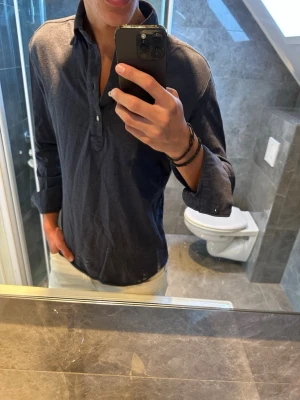 Mörkblå henley skjorta i bomull - Riktigt schysst marinblå henley skjorta från John Henric. Den är i riktigt bra skick och har inga skador. Jag på bilden är 188cm och bör storlek M på bilden. Hör av er vid fler frågor:)
