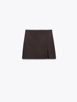 Brun kortkjol med slits - Snygg mörkbrun byxkjol med en diskret slits framtill. Kjolen har en enkel och stilren design som passar perfekt till många olika outfits. Tillverkad i ett mjukt material som ger en bekväm passform.