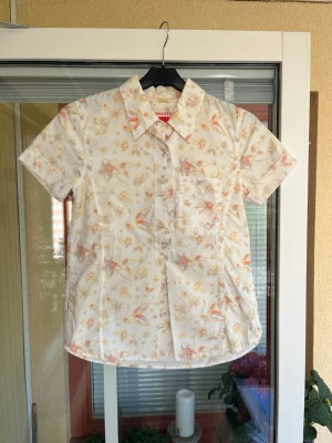 Kortärmad skjorta Levi's - Kortärmad skjorta från Levi's i ljus bomull med blommigt mönster i gult, lila och orange.. Storlek XS.