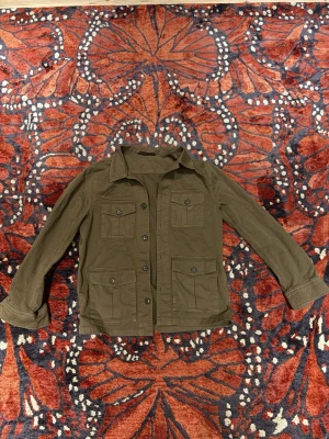 Oscar Jacobson overshirt grön  - Oscar Jacobson overshirt (Safari skjortjacka) mörkgrön/olivgrön. Storlek S. Skick 10/10 Väldigt sparsamt använd så skicket är nästan som nytt. Köpt ny för 2500kr. Tveka inte att höra av er vid frågor!