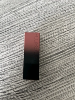 Huda Beauty läppstift Girls Trip - Snyggt matt läppstift från Huda Beauty i färgen Girls Trip. Hylsan har en cool ombre-design i rosa och svart. Perfekt för dig som vill ha ett trendigt och pigmenterat läppstift med lyxig känsla.