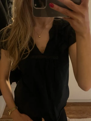 Svart blus  - En söt svart blus med spets och volanger upptill🩷