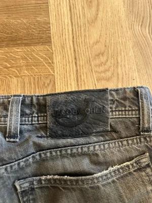 Grå jeans från Jacob Cohen - Snygga grå jeans från Jacob Cohen med klassisk femficksmodell och diskret broderad logga på myntfickan. Jeansen har en mörkgrå tvätt och detaljer i silver. Tillverkade i mjukt denimtyg för en bekväm känsla.