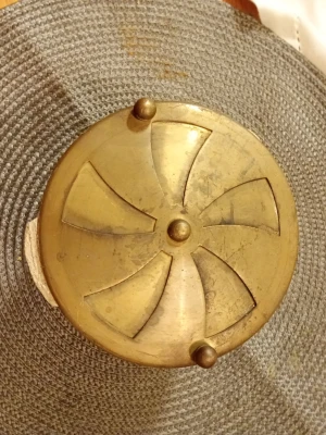 Rund  Sprilluvka mässingslockck med dekor - Säljer ett runt lock i mässing med dekorativt utskuret mönster och tre små kulor längs kanten. Locket är cirka 10 cm i diameter och har en vintage känsla. Perfekt som dekoration eller till ett projekt där du vill ha en unik detalj.