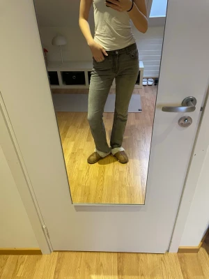 Grå utsvängda jeans med hög midja - Säljer ett par grå jeans med utsvängda ben och hög midja. Jeansen har klassisk femficksdesign och stängs med dragkedja och knapp. Perfekta till en avslappnad stil och passar till det mesta. Materialet är denim i bomull.