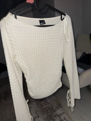 Vit ribbad långärmad topp Gina Tricot - Säljer en vit ribbad långärmad topp från Gina Tricot. Toppen har snörning i sidorna och är tillverkad i ett mjukt, stretchigt material med struktur. Perfekt till jeans eller kjol för en trendig look.