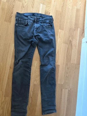 Gråa jeans från Replay - Snygga gråa jeans från Replay med raka ben och klassisk femficksmodell. Jeansen har diskreta sömmar och svart Replay-lapp bak i midjan. Tillverkade i mjukt denimtyg som ger en skön känsla och stilren look.