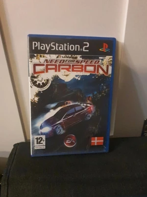 Need for Speed Carbon PS2 spel - Need for Speed Carbon till PlayStation 2 är ett racingspel med snyggt omslag i blå plastfodral. Spelet har en cool bil på framsidan och är märkt för åldrar 12+. Perfekt för dig som gillar fartfyllda bilspel och street racing.