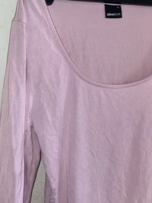 Ljusrosa långärmad topp Gina Tricot - Trendig ljusrosa långärmad topp från Gina Tricot med rundad urringning. Tillverkad i mjukt bomullsmaterial som sitter tight mot kroppen. Perfekt att styla med jeans eller kjol för en clean och enkel look. Andra bilden är likadan tröja men i annan färg då den inte säljs i rosa längre