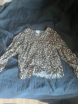 Leopardmönstrad blus från Saint Tropez - Snygg leopardmönstrad blus från Saint Tropez med v-ringning och långa ärmar. Tillverkad i ett tunt, luftigt material som ger en avslappnad och trendig look. Perfekt för dig som vill sticka ut med ett djurmönster💓 använd fåtal gånger💓