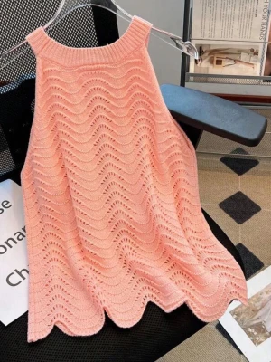 Ljusrosa stickad ärmlös topp - Supersöt ljusrosa stickad topp med vågigt hålmönster och ribbad halsringning. Toppen är ärmlös och har en luftig, flowy passform som känns både trendig och bekväm. Perfekt att styla med jeans eller kjol för en fräsch look.