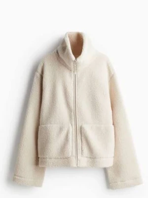 Beige teddyjacka med dragkedja - Mysig beige teddyjacka med hög krage och dragkedja framtill. Jackan har två stora fickor fram och är tillverkad i fluffigt, mjukt material som ger en avslappnad och trendig look. 