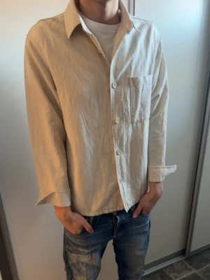 Beige skjorta  - Stilren beige skjorta i mjuk bomull med klassisk krage och knäppning framtill. Perfekt för en avslappnad men snygg look till våren/sommaren. Den är i storlek M men lite luftig.