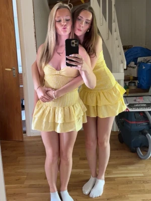 Gul rutig volangklänning - Söt gul kortklänning med rutigt mönster och volangdetaljer. Klänningen har v-ringning, smala axelband och en liten rosett framtill. Perfekt för varma dagar och ger en fräsch sommarkänsla. Storlek M från Zara men passar mig som har xs! 