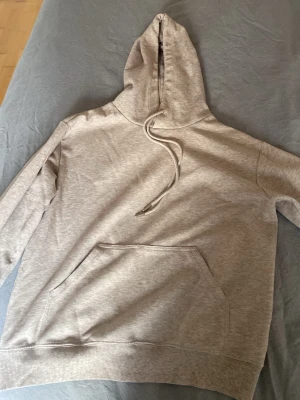 Ljusrosa/beige basic hoodie med huva - En stilren ljusrosa/beige. Perfekt för en avslappnad look. Inga synliga loggor eller tryck, enkel och clean design som passar till det mesta.