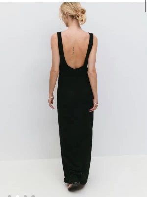 Svart långklänning med öppen rygg - Stilren svart långklänning med djup urringning i ryggen och breda axelband. Klänningen har en kroppsnära passform och är ärmlös i storlek XXS. Helt ny, aldrig använd.