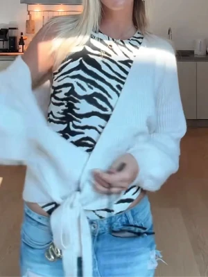 Zebramönstrad ärmlös body - Säljer en snygg ärmlös body med zebramönster i svart och vitt. Bodyn har rund halsringning och är tillverkad i ett stretchigt material som sitter tajt mot kroppen. Perfekt för dig som vill sticka ut med ett djurmönster i garderoben.