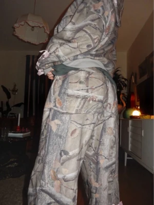 NAMED collective camo mjukisbyxor - Camo mjukisbyxor med rosa korsettdetaljer från NAMED Collective, använd sparsamt ett fåtal gånger 