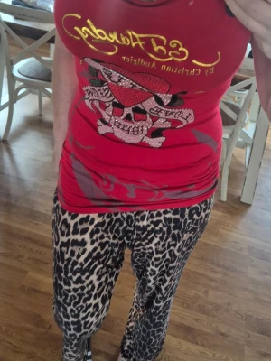 Ny röd Ed Hardy klänning eller lång topp! Storlek One Size 36-42 - Cool röd linnetopp från Ed Hardy med stort tryck av dödskalle, hjärta och texten 'Kills Love Slowly' framtill. Toppen har ett avslappnat fall och bred urringning. Materialet är mjukt och lätt, perfekt för varma dagar. Stretchig och många snygga detaljer!                        Djur och rökfritt hem.                                                     Ny, endast lappar borttagna!                                       Djur och rökfritt hem.     One size fits all 36-42