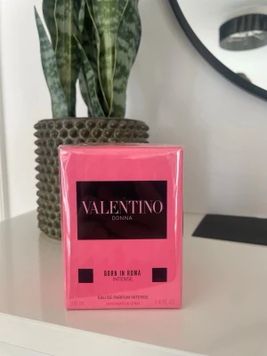 Valentino Donna Born In Roma Intense EdP - Valentino Donna Born In Roma Intense Eau de Parfum i en snygg rosa förpackning. Parfymen har en lyxig och modern design med svart etikett och rosa kartong. Flaskan innehåller 100 ml och är perfekt för dig som gillar exklusiva dofter.