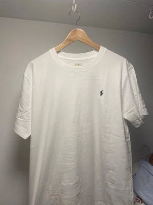 Vit t-shirt från Polo Ralph Lauren - Klassisk vit t-shirt från Polo Ralph Lauren med liten broderad logga på bröstet. Inga defekter true 2 size perfekt till dessa varma dagar som kommer strax.