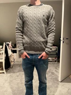 Grå kabelstickad tröja Polo Ralph Lauren - Kabelstickad tröja med kashmir blandning i grått från Polo Ralph Lauren.  Mycket fint skick 
