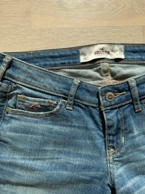 Blå Hollister jeans  - Snygga blåa low waist jeans från Hollister som är helt oanvända. Bakfickan har dekorativa sömmar och tillverkade i mjukt denimtyg. Skriv vid minsta fundering!🌸