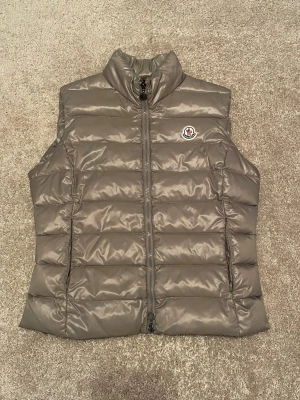 Moncler väst - Moncler ghany down gilet väst i storlek 4 passar s-m, skick 8/10 ena dragkedjan fungerar ej, sedan en liten fläck (se bild 7), nypris ca 9500kr  hör av er vid funderingar