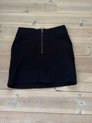 Svart kjol med dragkedja  - Säljer denna snygga svarta kjol med dragkedja från divided i storlek 36💕Den är i mycket bra skick. Inga fickor bak.