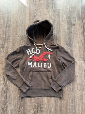 Hollister Malibu hoodie ~ Sällsyntaste hoodien - Väldigt sällsynt hoodie | Hollister Malibu | Brun | Archive - Vintage | Storlek: M | Mycket bra skick | Den ska se lite ”sliten ut” | Väldigt eftertraktad hoodie | Tar emot prisförslag - Priset är ej hugget! Hör av er vid frågor eller funderingar!🤝